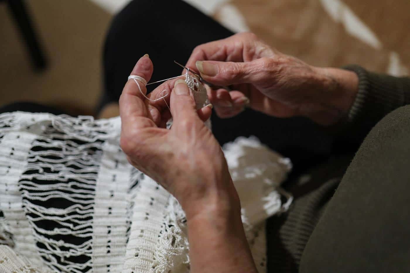 The hands of an older woman crocheting
